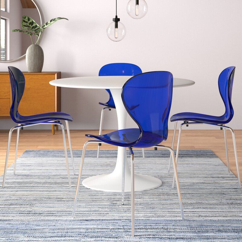 LeisureMod 5-Piece Dining Set Round White MDF Dining Table and 4 Plastic Dining Chairs with Chrome Legs Transparent Blue in Room.