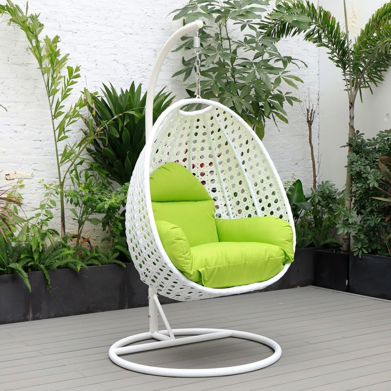 LeisureMod White Wicker Hanging Egg Swing Chair Light Green on Patio.