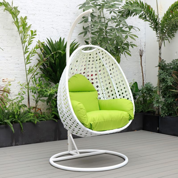 LeisureMod White Wicker Hanging Egg Swing Chair Light Green on Patio.