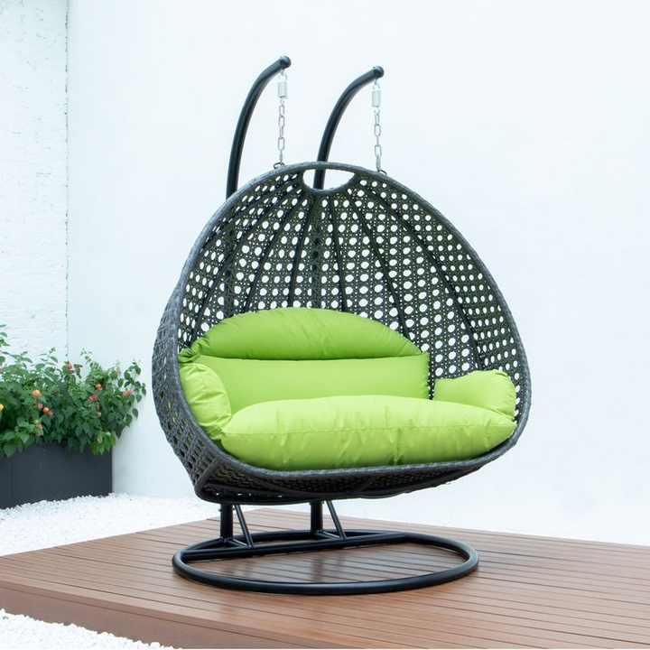 LeisureMod Charcoal Wicker Hanging 2 person Egg Swing Chair Light Green on Patio.