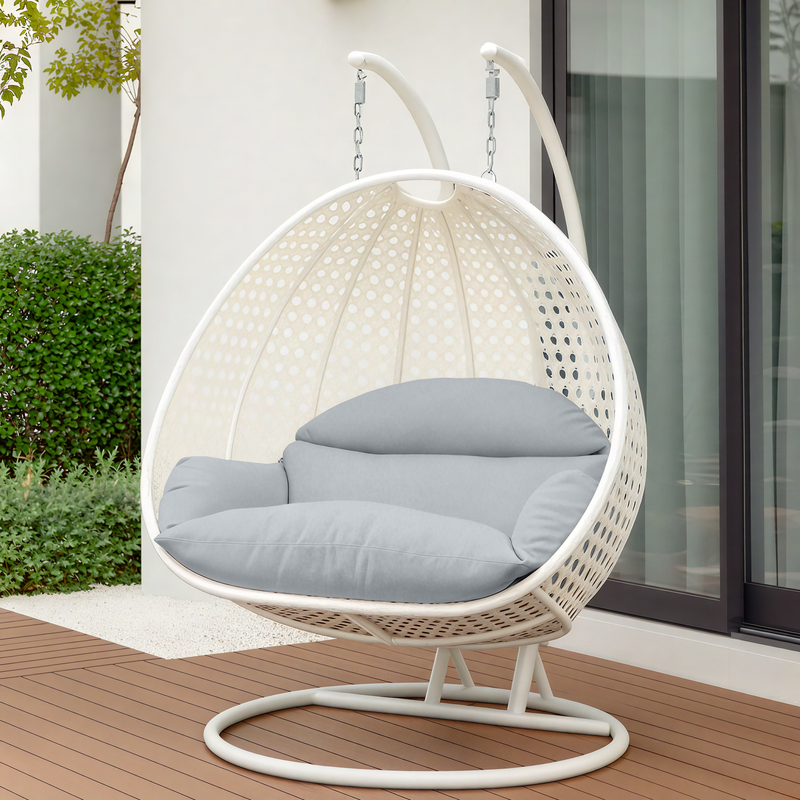 LeisureMod White Wicker Hanging 2 person Egg Swing Chair Light Grey on Patio.