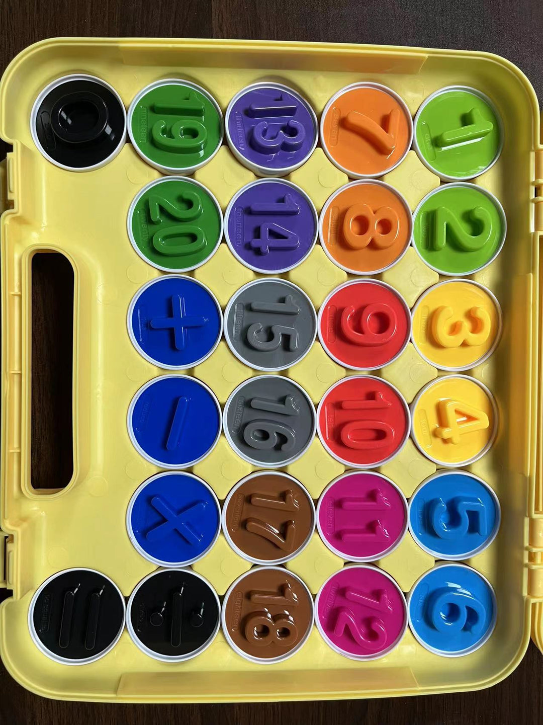 Set of colorful number and math symbol magnets in a yellow storage case.