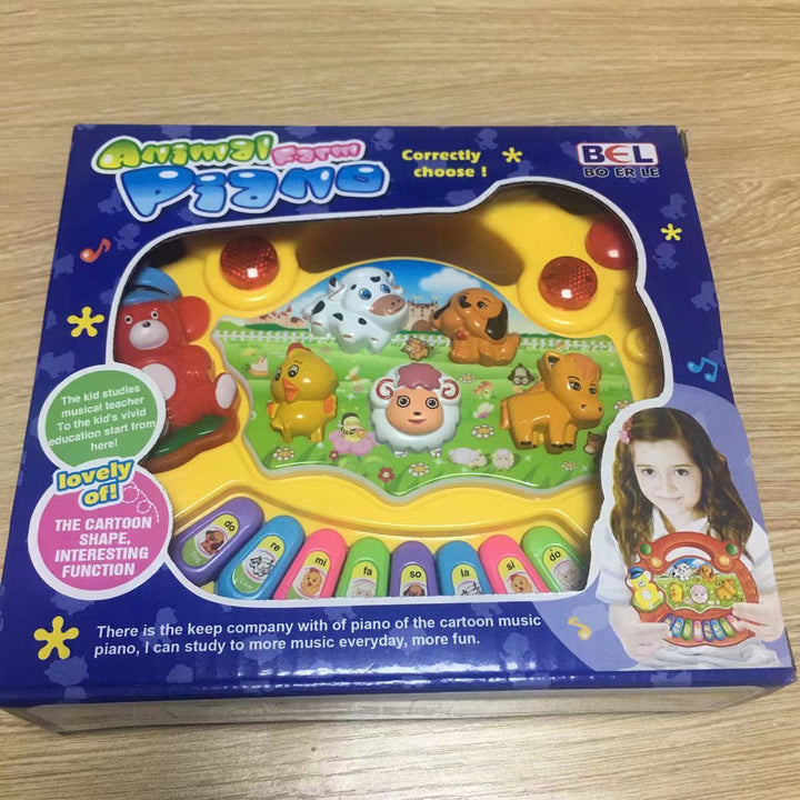 Children's piano toy packaging with cartoon characters on a wooden surface.
