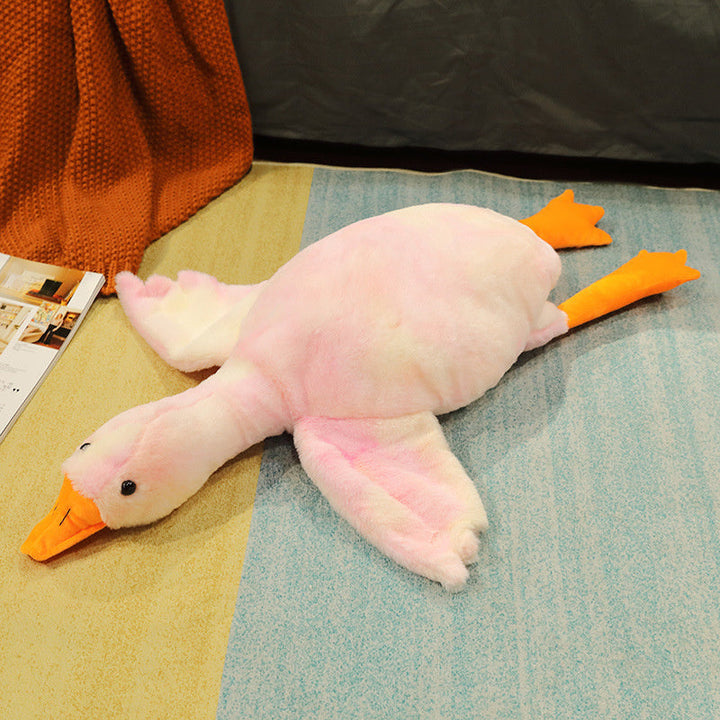 Plush toy duck on a textured surface with a magazine in the background.