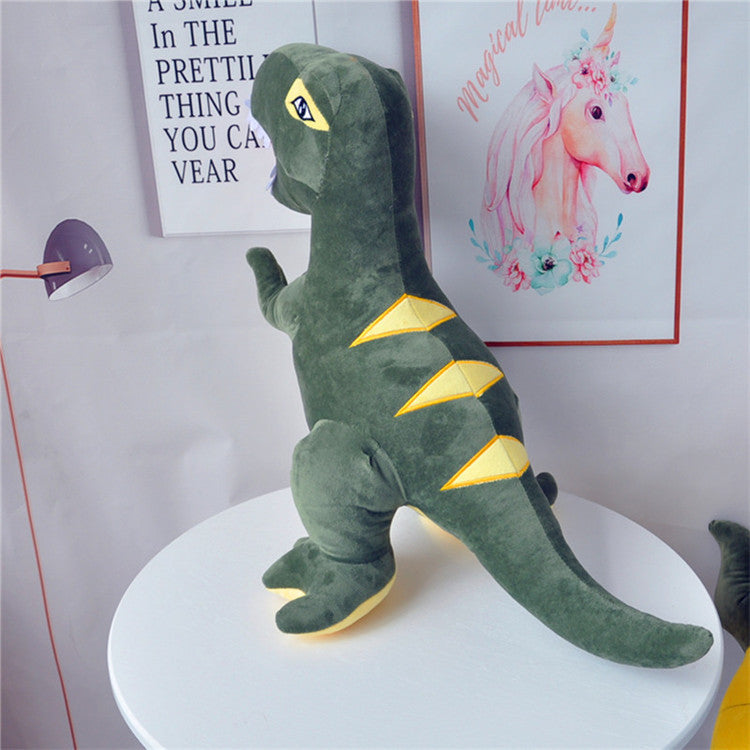 Green dinosaur plush toy on a white surface with posters in the background.
