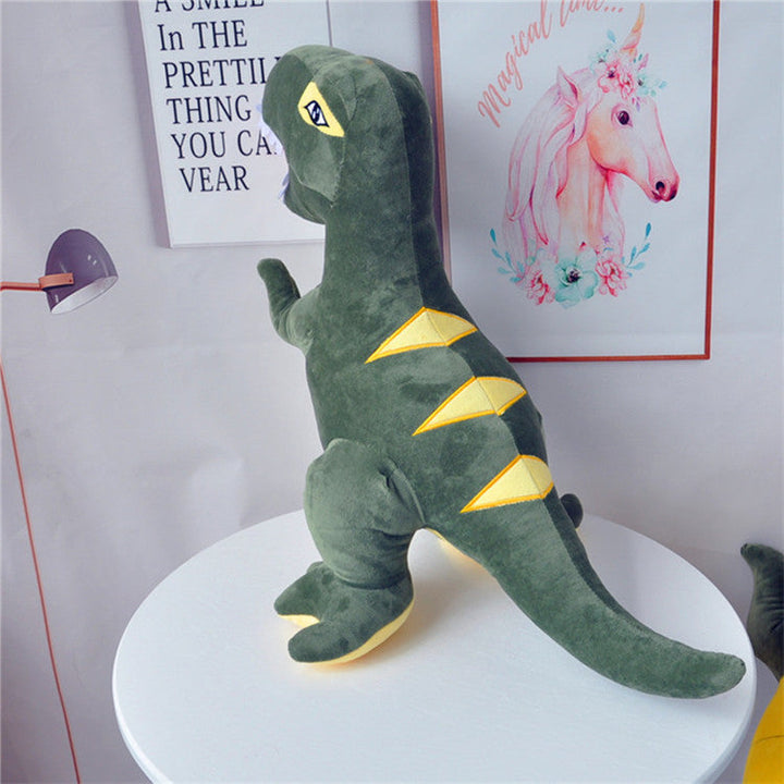 Green dinosaur plush toy on a white surface with posters in the background.
