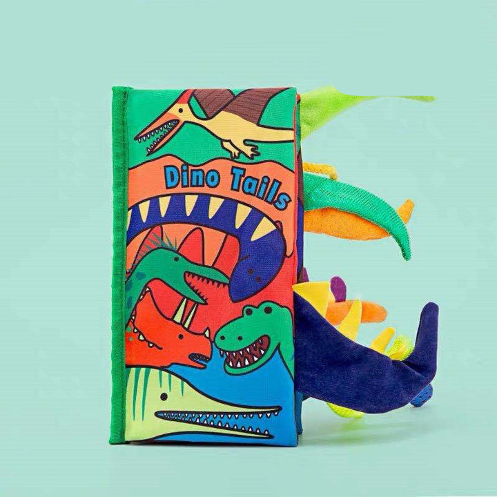 Colorful dinosaur-themed soft book with a green background.