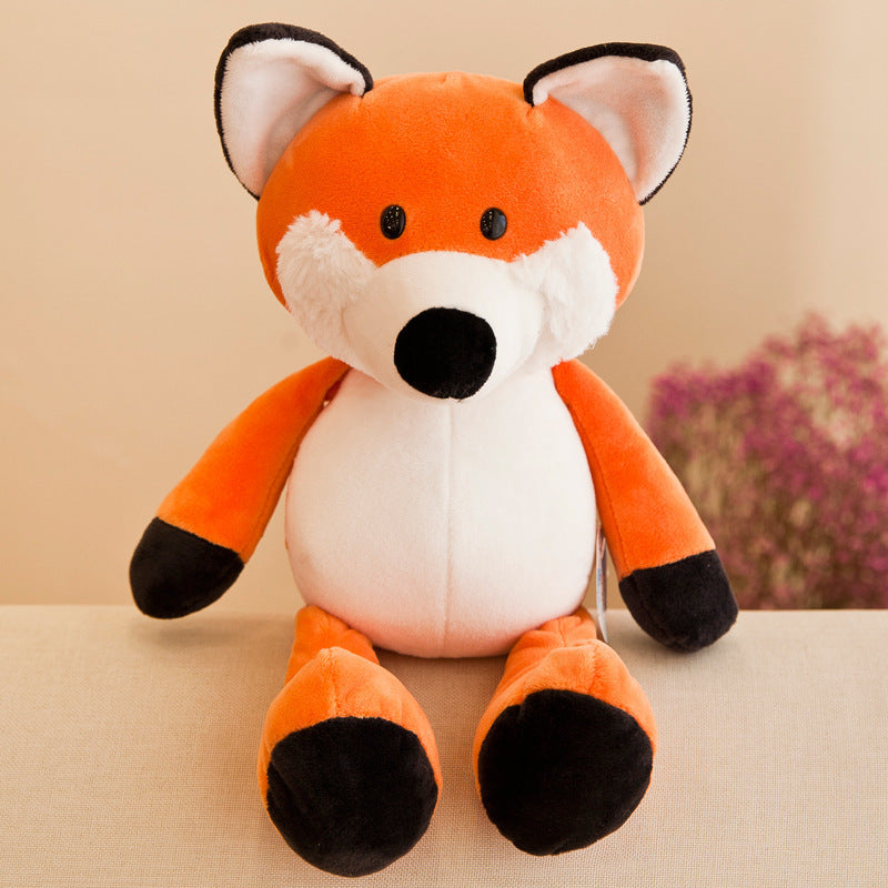 Plush toy fox sitting on a beige surface with a blurred floral background.
