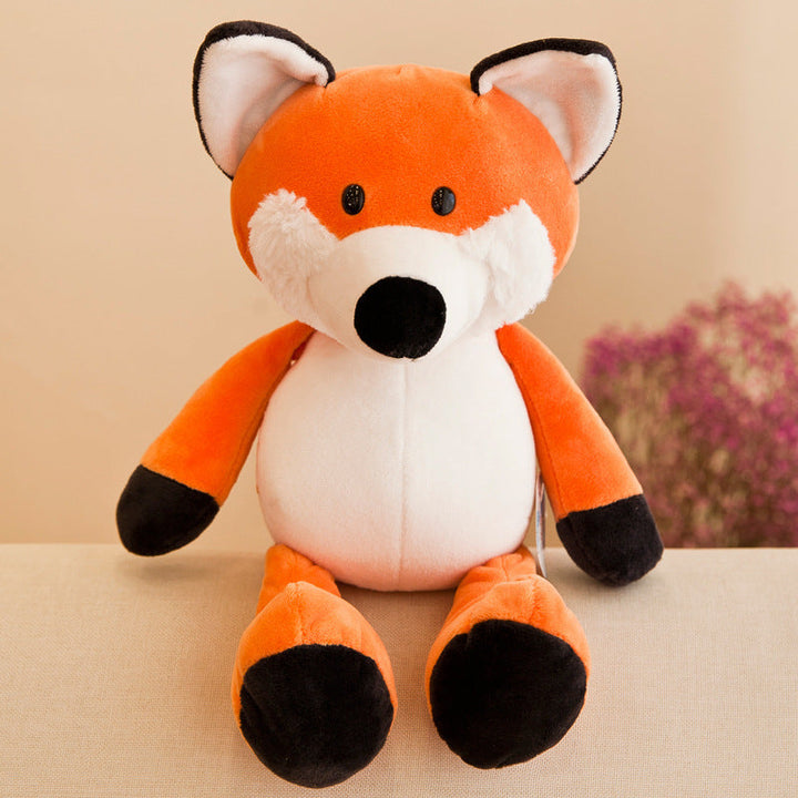 Plush toy fox sitting on a beige surface with a blurred floral background.