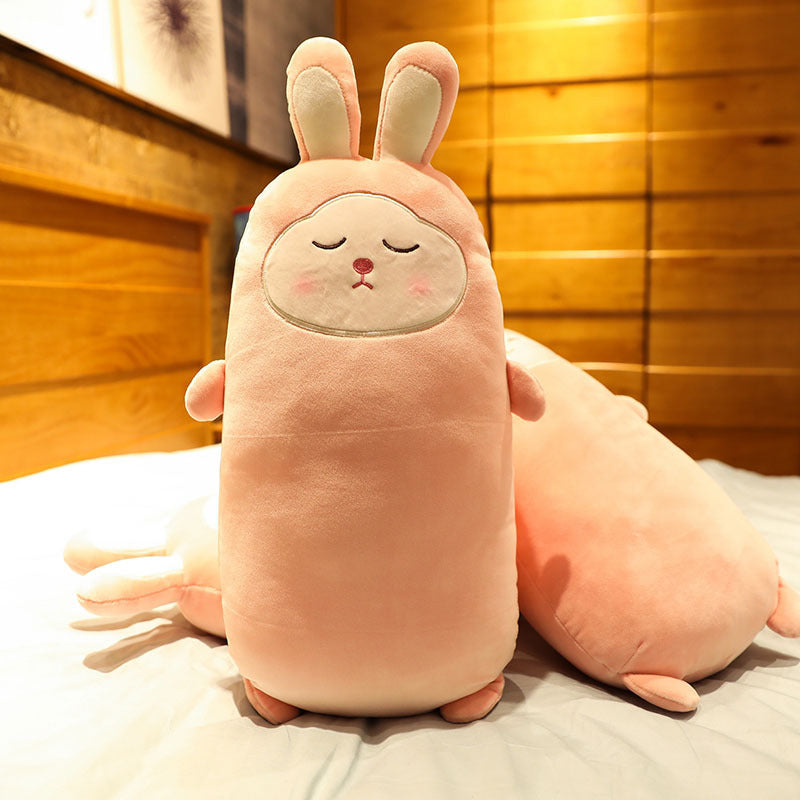 Plush toy resembling a pink creature with bunny ears on a wooden floor.