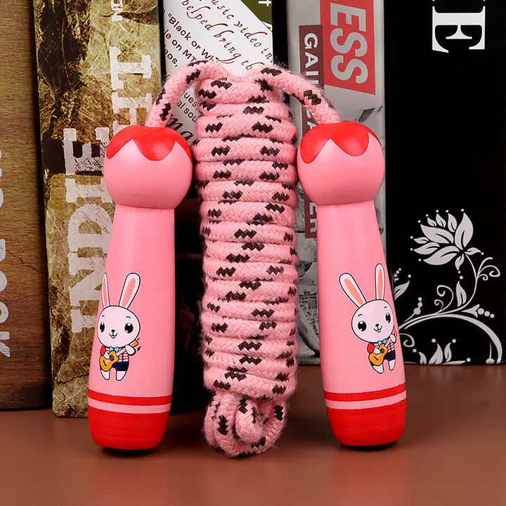Pink jump rope with cartoon bunny design on handles against a magazine background.