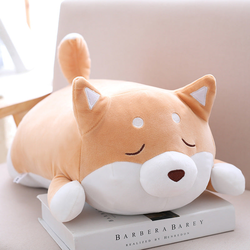 Plush dog-shaped pillow on a book.