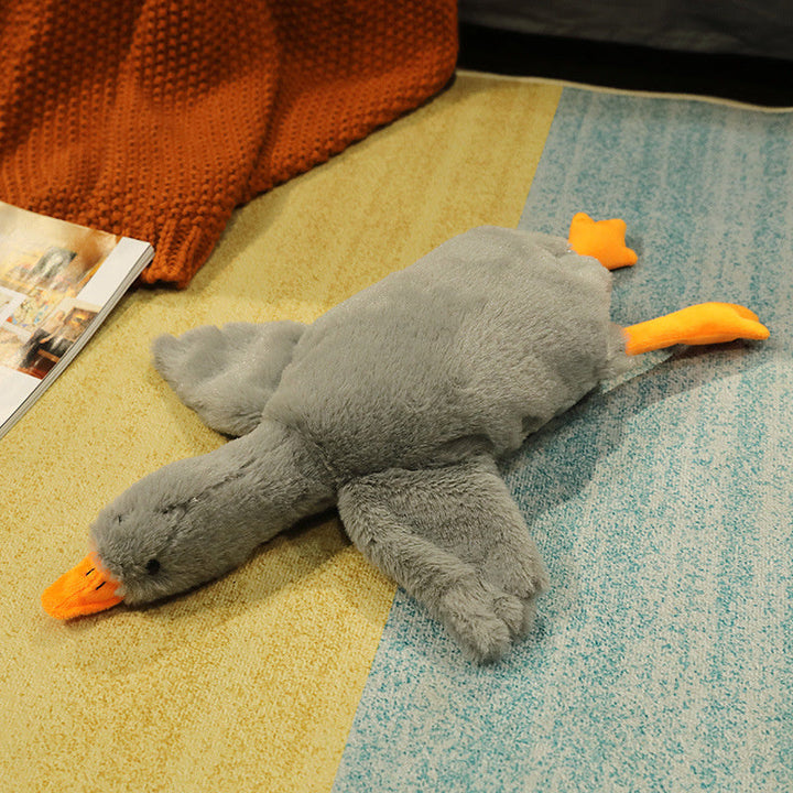 Plush toy duck on a textured surface with a magazine in the background.