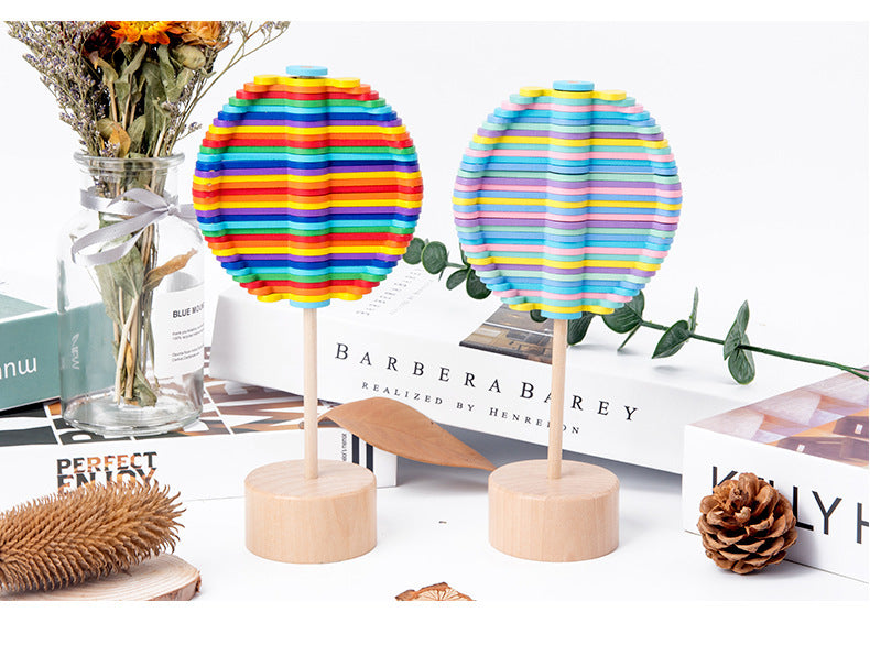 Two colorful striped lollipops on stands with a decorative background.