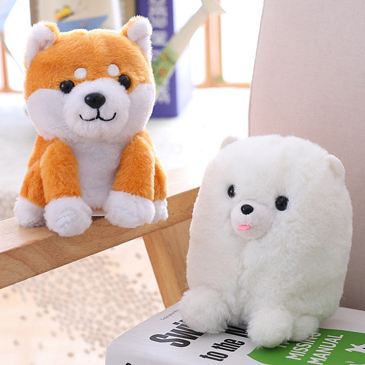 Two plush toys, one orange and white, the other white, on a surface with a blurred background.