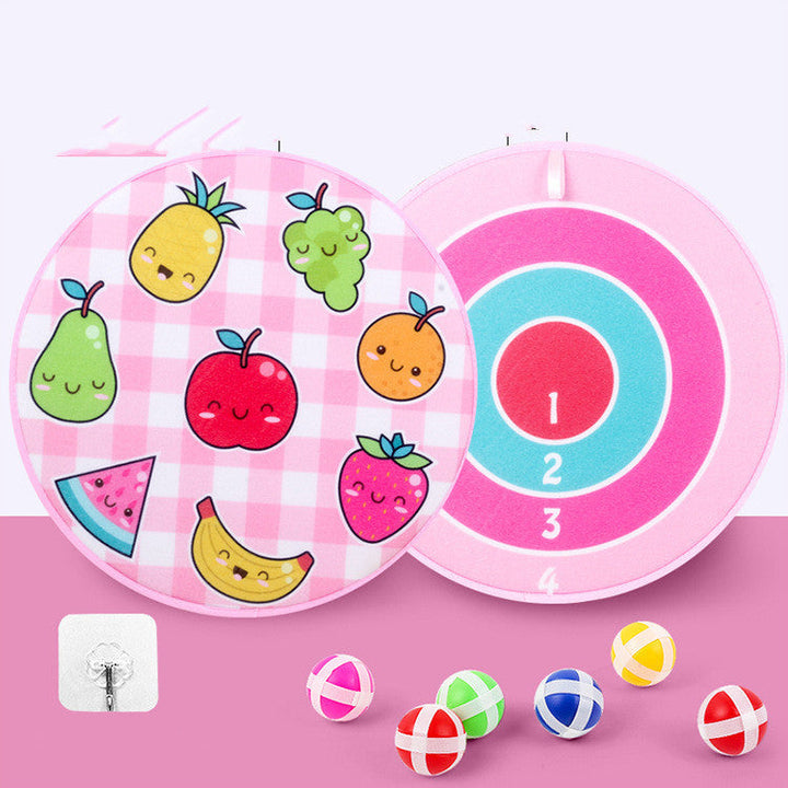 Pink dartboard with cartoon fruits and colorful darts on a pink background.
