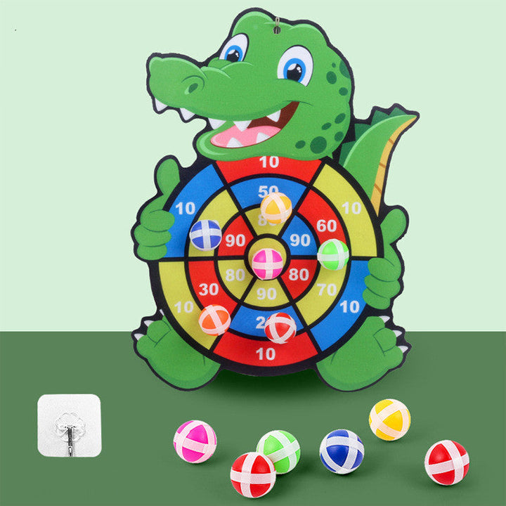 Children's dartboard shaped like a crocodile with colorful darts on a green background.