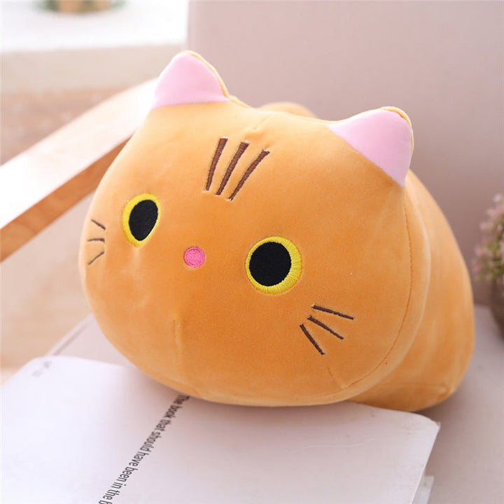Plush cat pillow on a surface with a light background.