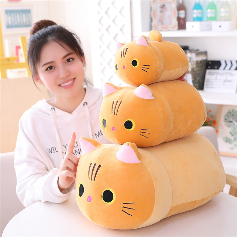Stack of cat-shaped plush toys with a person sitting behind them.