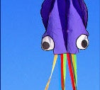 Cartoon octopus kite with rainbow stripes against a blue sky.