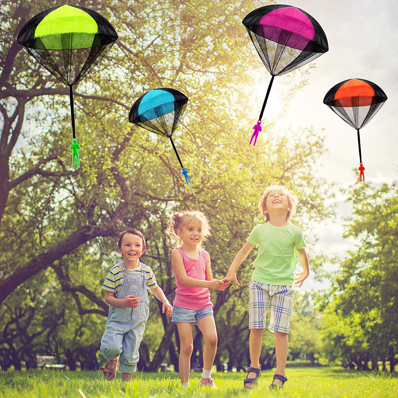 Children playing with colorful parachutes in a park.
