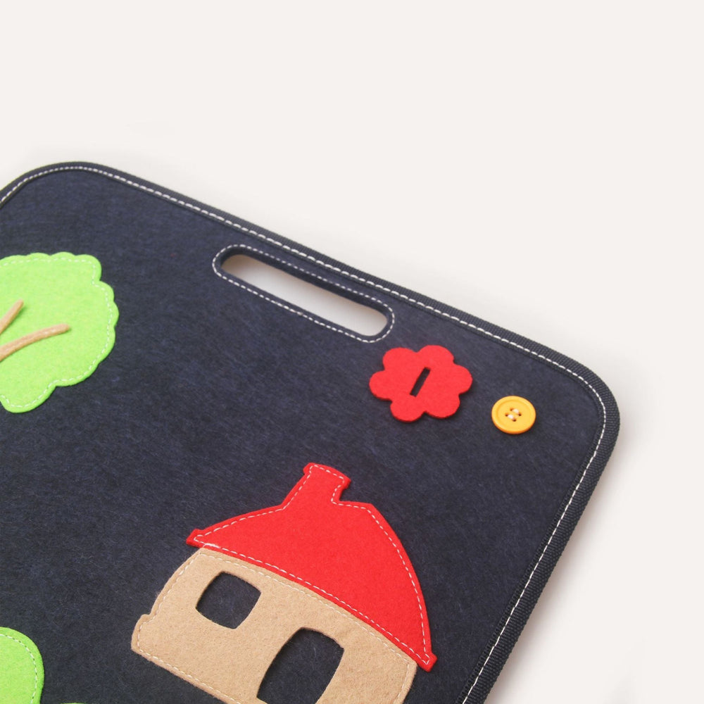 Children's felt board with house, tree, and flower designs on a white background.