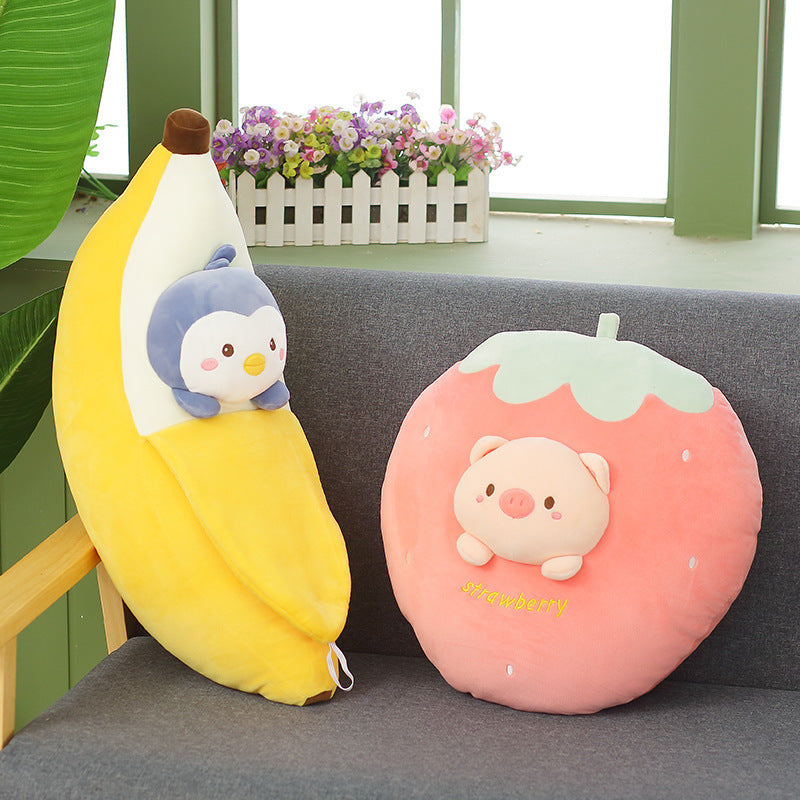 Plush banana and strawberry pillow with cartoon characters on a gray couch.