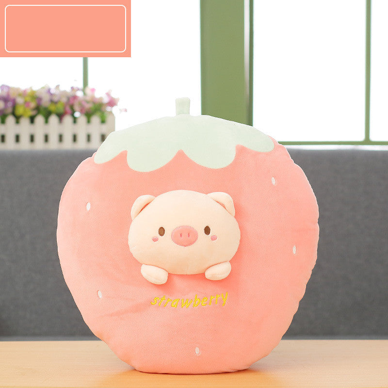 Pink strawberry-shaped plush toy with a pig design on a blurred indoor background.