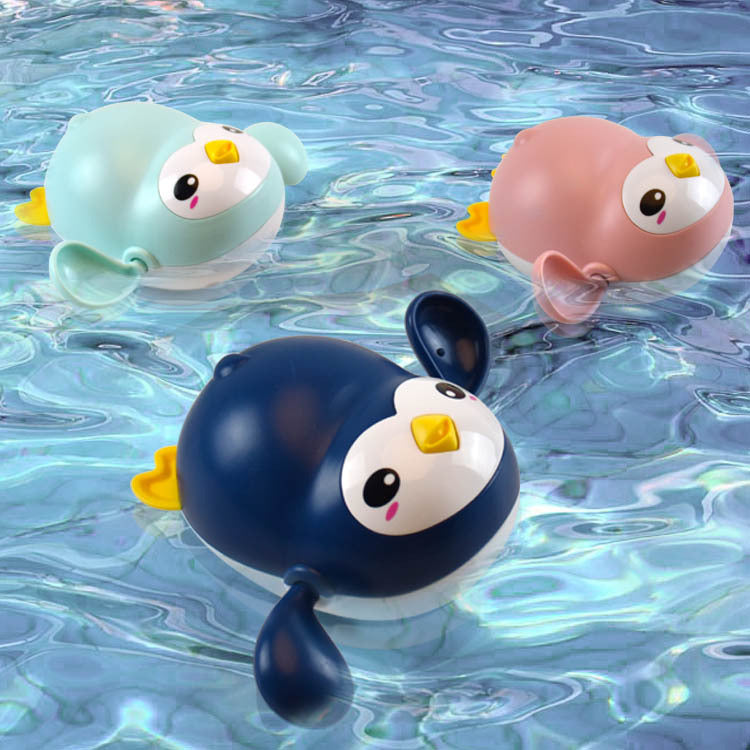 Three cartoon-style penguin bath toys floating on water.