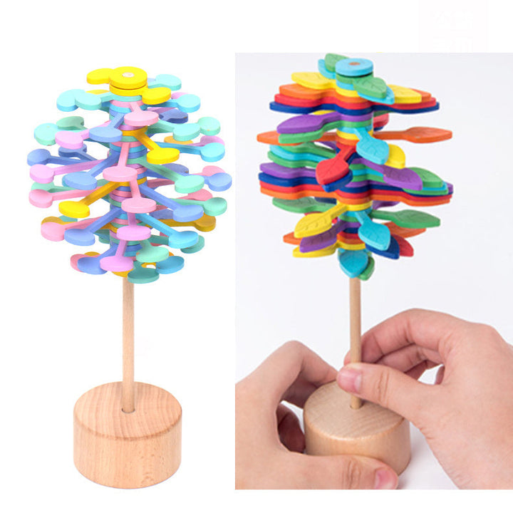 Colorful wooden tree toys with a hand interacting with one of them on a white background.