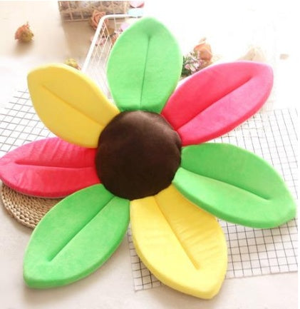 Colorful flower shaped cushion on a checkered surface.