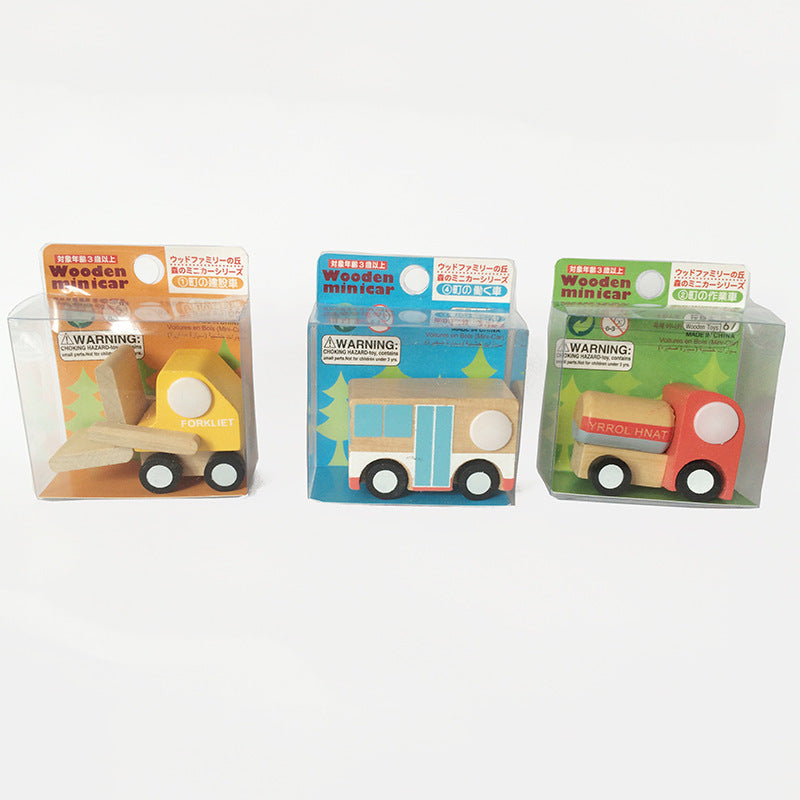 Three wooden toy vehicles in packaging on a white background.