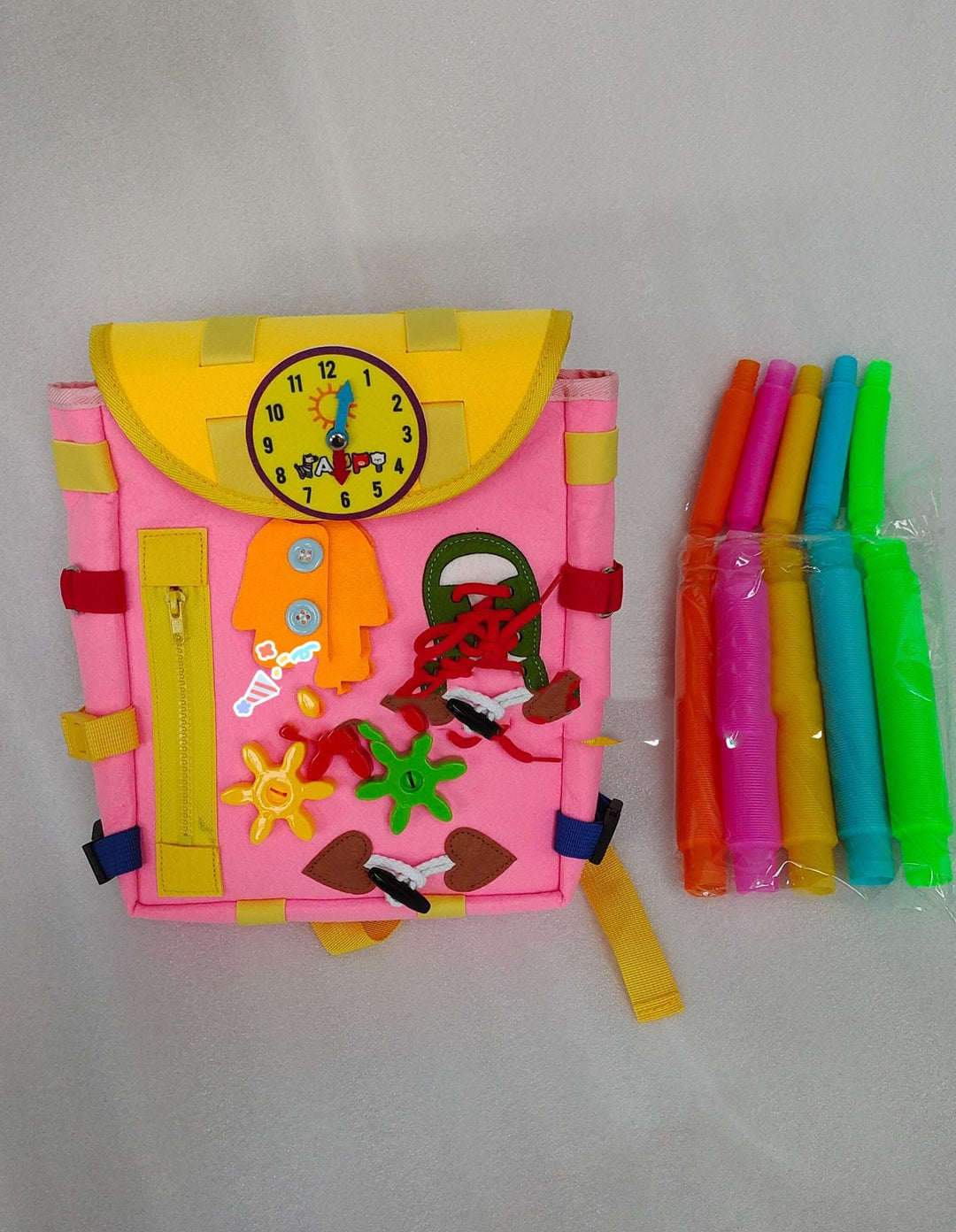 Colorful children's book with felt stickers and a set of straws on a gray background.