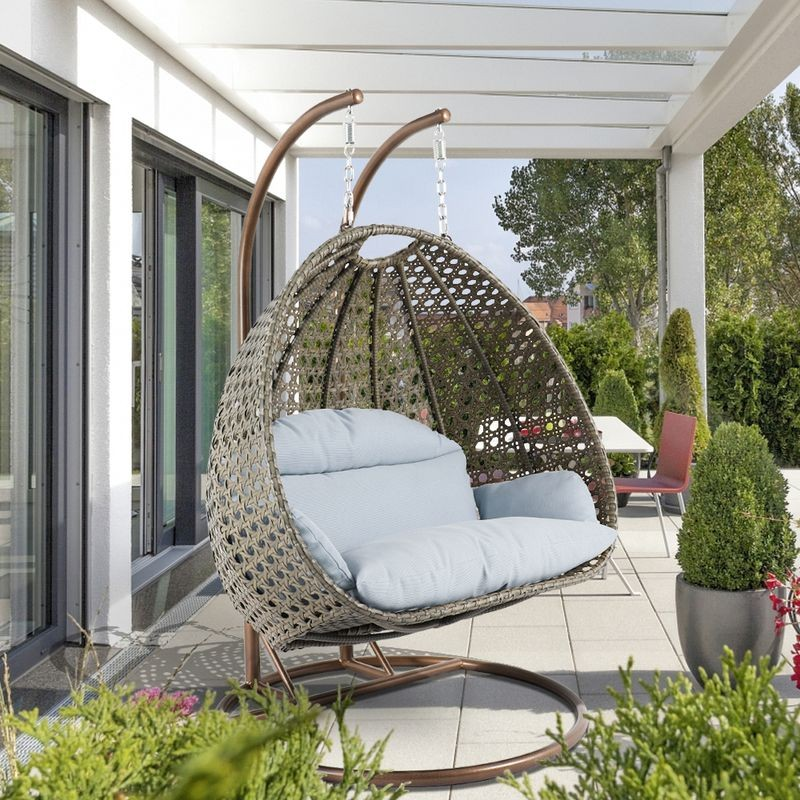LeisureMod Beige Wicker Hanging 2 person Egg Swing Chair Light Grey on Patio.