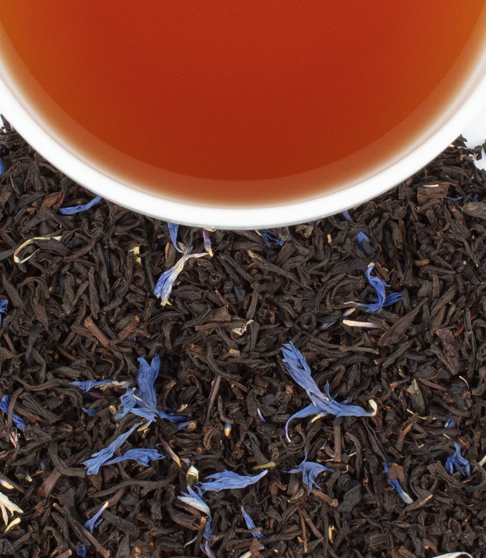 Close-up of tea leaves with a cup of tea on top.
