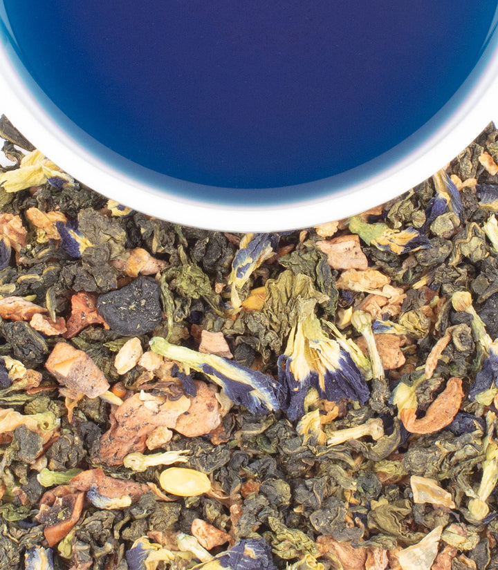 Close-up of a cup filled with a mix of dried tea leaves and flowers, with a blue interior.