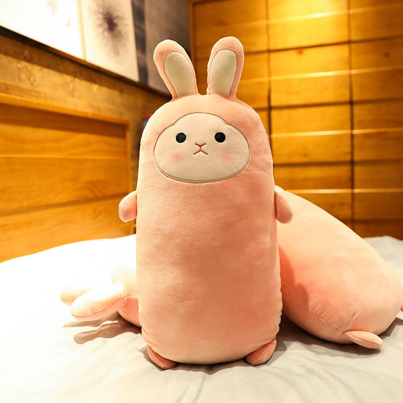 Plush toy shaped like a rabbit on a bed with wooden paneling in the background.