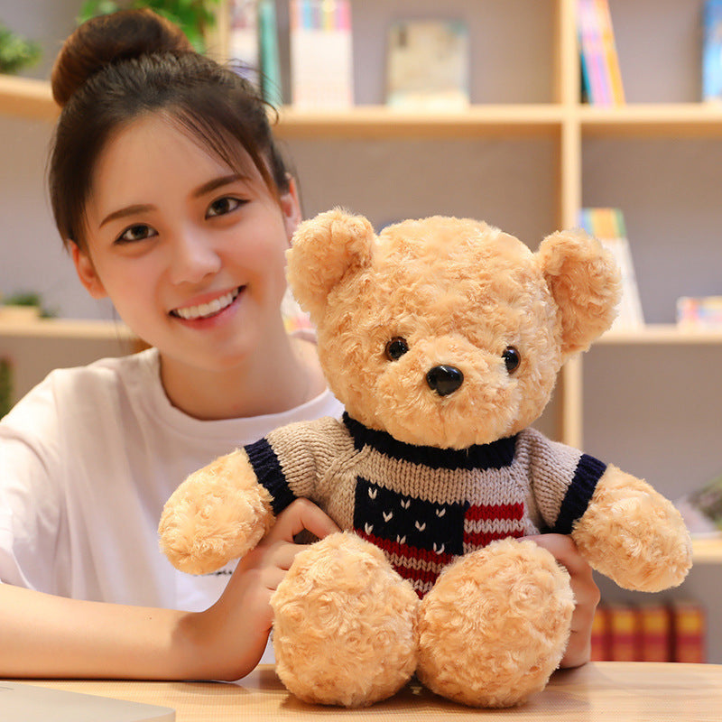 Woman holding a teddy bear with a blurred bookshelf in the background.