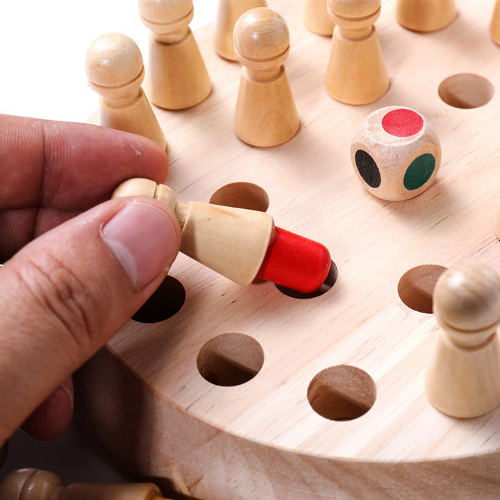 Wooden game piece with red bottom being placed on a wooden board with other pieces and a dice.