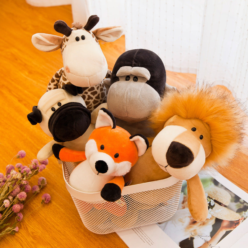 Set of plush animal toys including a giraffe, cow, sheep, and lion in a basket on a wooden surface.
