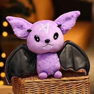 Purple bat plush toy with black wings in a woven basket against a blurred background.