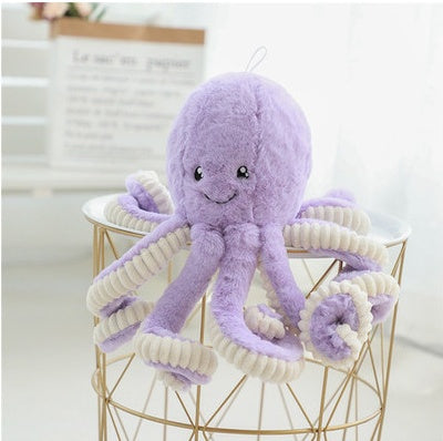 Purple plush octopus toy on a gold wire chair with a white background.