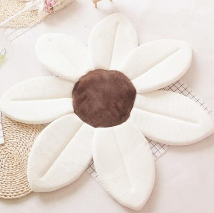 Floral-shaped cushion with a brown center on a light surface.