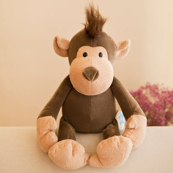 Stuffed monkey toy on a light surface with a blurred floral background.