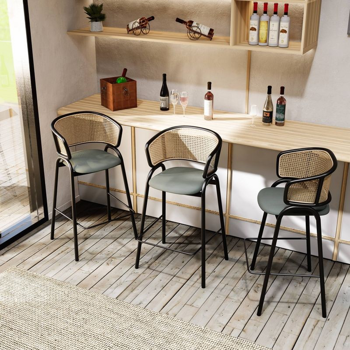 LeisureMod Ervilla Wicker Bar Stool with Fabric Seat and Black Steel Frame in Grey Leather at Bar.