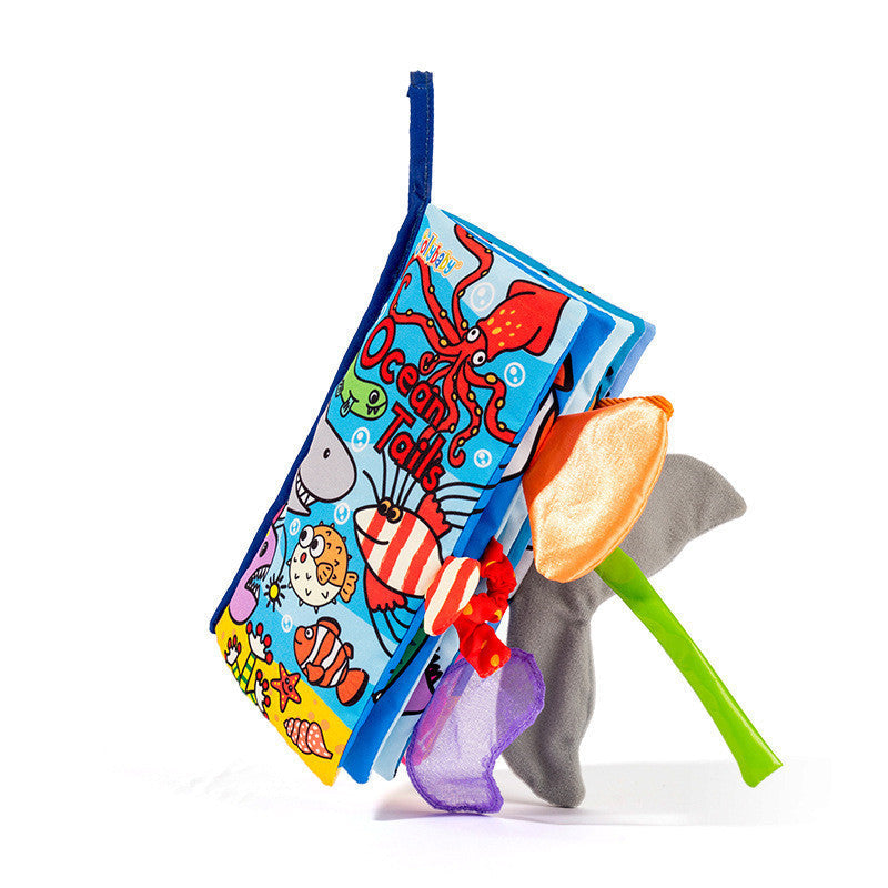Colorful children's book with ocean-themed illustrations and a toy spoon on a white background.