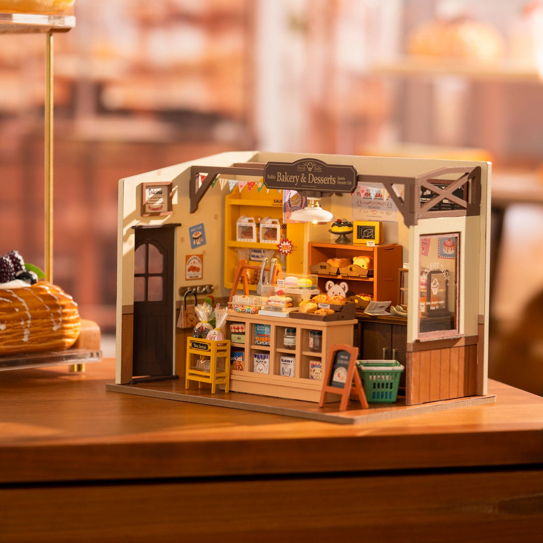 Miniature bakery model on a wooden surface with a blurred background.