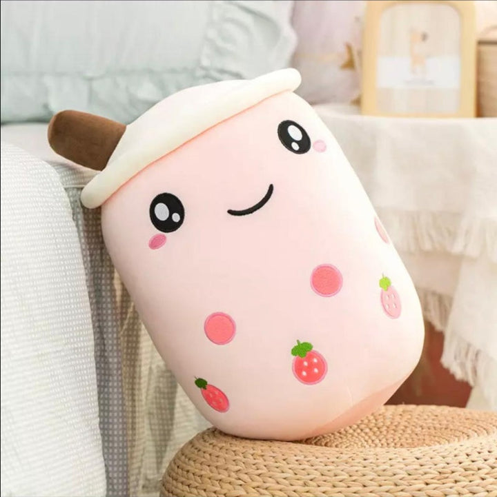 Cute plush toy with a face on a soft surface.
