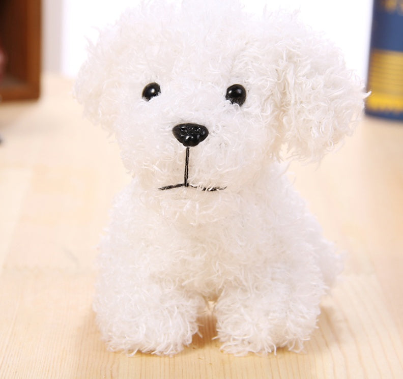 White plush toy dog on a light wooden surface.