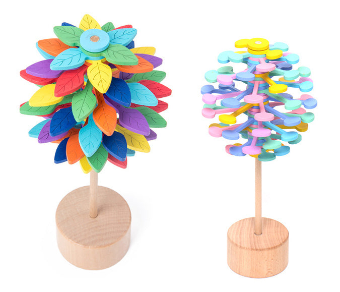 Two colorful wooden trees on stands against a white background.